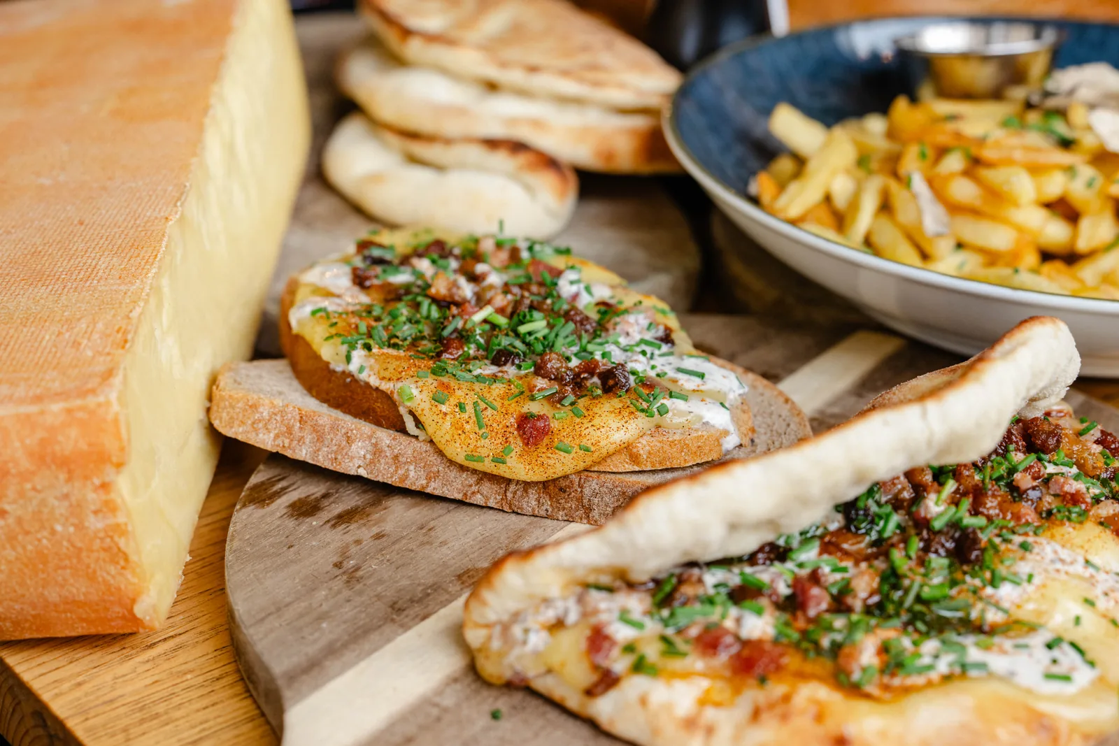 Mit Raclettekäse überbackenes Brot und Beilagen